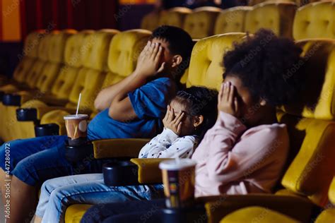 Young Boy And Girls Sitting In Movie Theater With Cold Drinks Closing