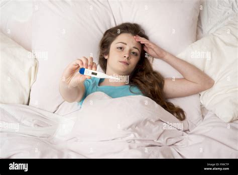 Sick Woman With Thermometer Is Lying In Bed She Has Cold Flu And High