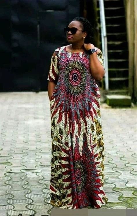 A Woman In A Colorful Dress Is Standing On The Street And Talking On