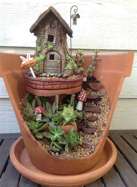 A Potted Planter Filled With Succulents And A Small House On Top