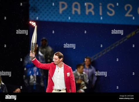 Paris France 26 July 2024 Rafael Nadal Of Team Spain Holds Aloft The Olympic Torch During The