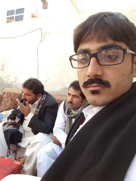 A Group Of Men Sitting Next To Each Other In Front Of A Building With