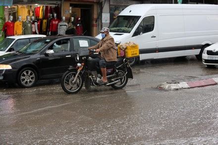 Palestinians Walk In A Street During A Rainy Day Dair Al Balah Gaza