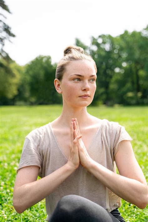 Young Fit Blond Woman Sitting In Lotus Yoga Pose With Hands As In