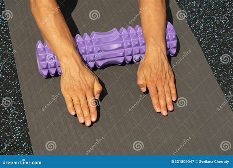 Athlete Man Stretching Arms on Foam Roller on Sports Ground. Outdoor
