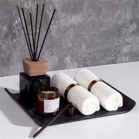 A Tray With Candles Reeds And Some White Towels On It Next To A Bottle