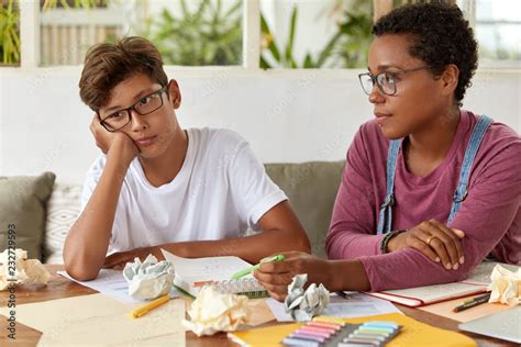 Multiracial Teenagers Do Homework Together Sit Together At Desktop