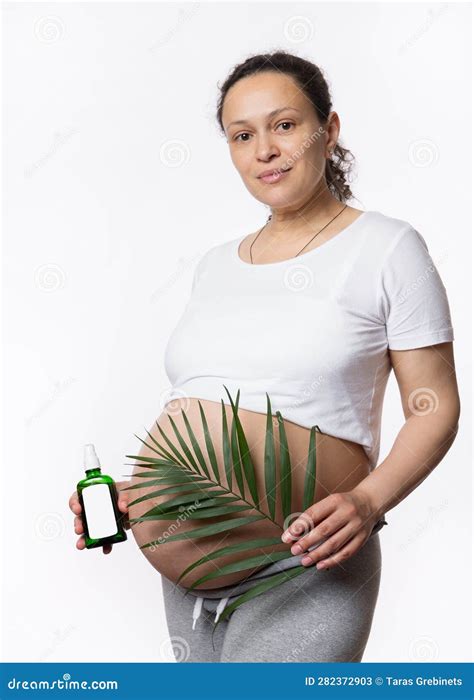 Gorgeous Multi Ethnic Pregnant Woman Holding Exotic Palm Leaf Cosmetic