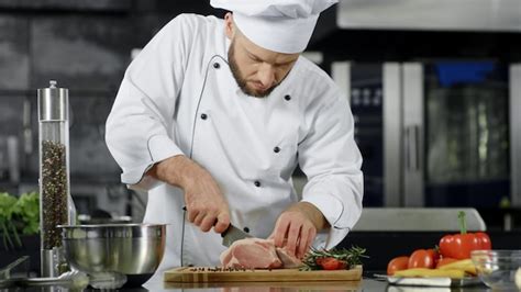 Chef Masculino Cortando Rebanadas De Carne En La Cocina Profesional