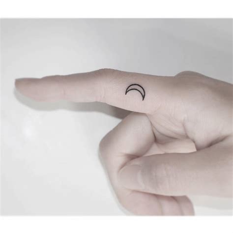 Minimalistic crescent moon tattoo done on the finger.