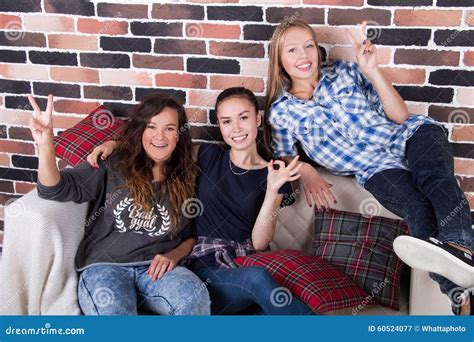 Se Reposer De Sourire De Trois Amies Sur Le Divan Image Stock Image