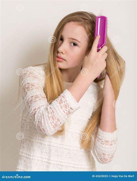 Fille Blonde Assez Jeune Se Brossant Les Cheveux Image Stock Image Du Tony Expression 42629035