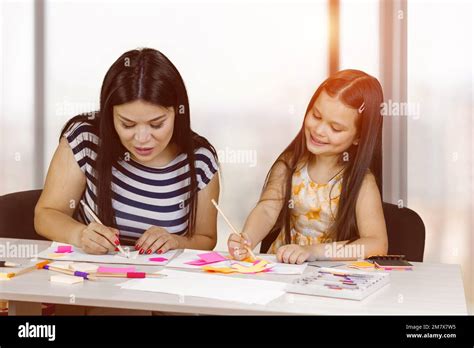 La mère Brunette et sa petite fille mignonne sont en train de dessiner ensemble Maman et sa