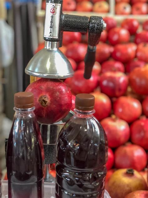 Frisch gepresster Fruchtsaft in Flaschen auf Eis, daneben Bananen ...