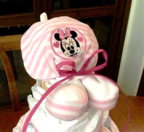 A Diaper Cake That Has A Minnie Mouse Hat On Top And Pink Ribbon Around It