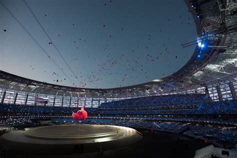 A Large Stadium Filled With Lots Of People Flying Kites In The Sky Above It