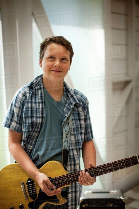 Teenage Boy Playing N Electric Guitar In A Garage Stock Photo Dissolve