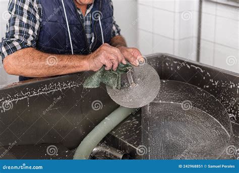 Old Hands Of An Elderly Person Scrubbing A Metal Filter Used In The