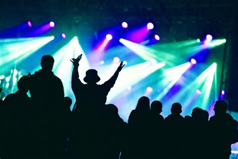 Premium Photo | Silhouette of hands on a concert in front of bright ...