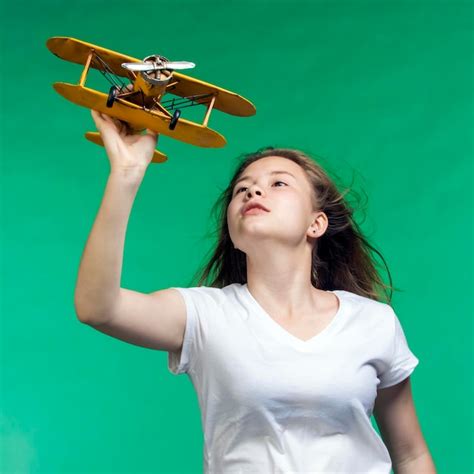 Chica con avión de juguete en la mano un símbolo de sueños y esperanzas