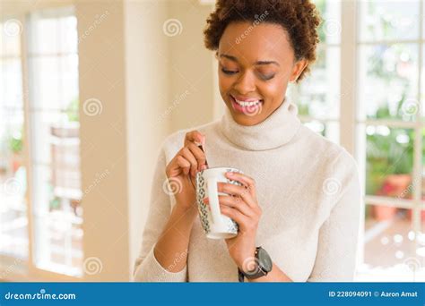 Beautiful Young African American Woman With Afro Hair Drinking A Cup Of