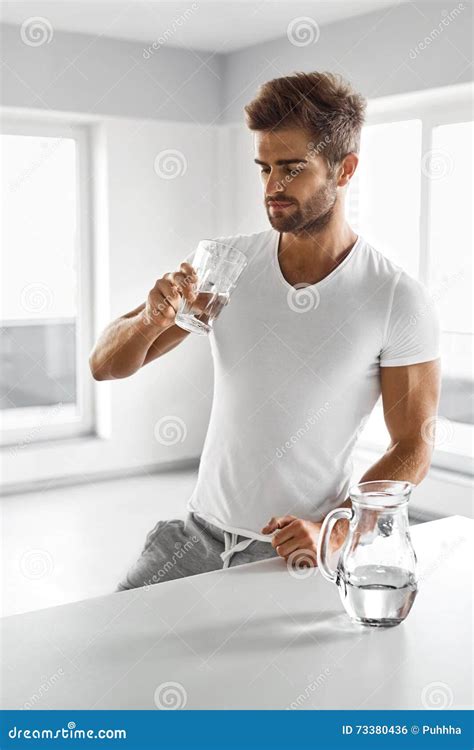 Handsome Man Drinking Glass Of Fresh Water Indoors In Morning Stock