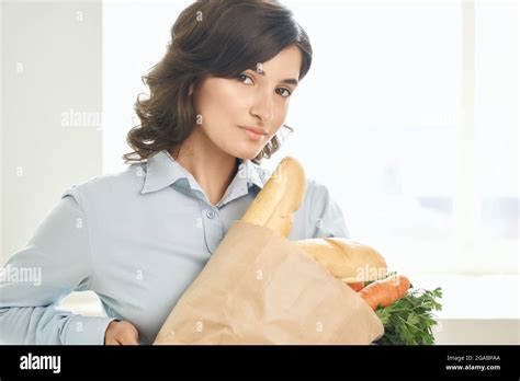 Brunette In The Kitchen With A Package Of Healthy Food Stock Photo Alamy