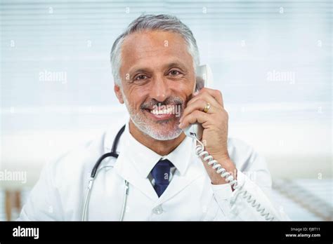 Doctor talking on phone Stock Photo - Alamy