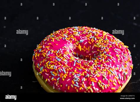 Pink Glazed Donut With Sprinkles Isolated Close Up Of Colorful Donut