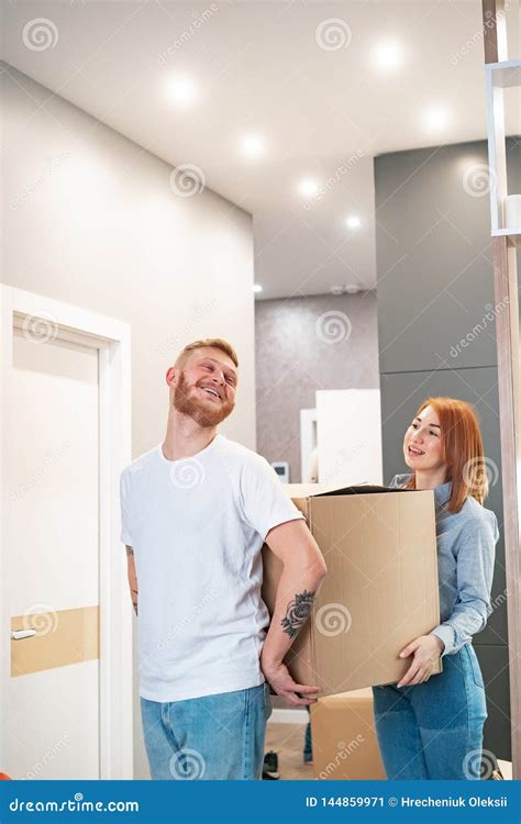 Happy Couple Holding Cardboard Boxes And Moving To New Place Stock