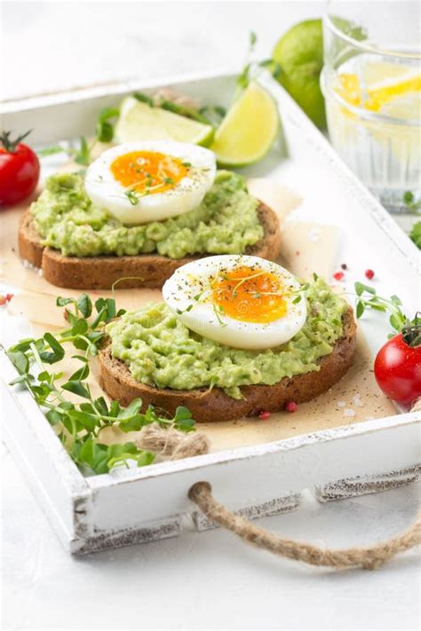 Toast With Avocado Puree And Soft Boiled Egg On White Tray Liquid Yolk