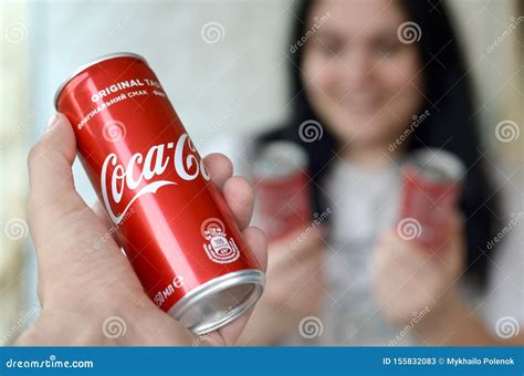 Happy Woman Holding Few Coca Cola Tin Cans In Garage Interior And Male