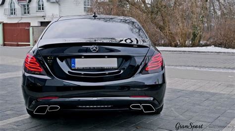 The Rear End Of A Black Car Parked In Front Of A House