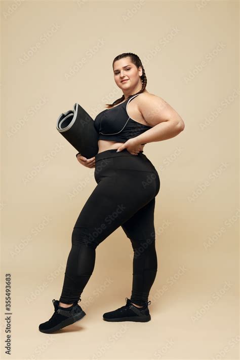 Plus Size Model Big Woman In Black Sportswear Full Length Portrait Smiling Brunette Holding