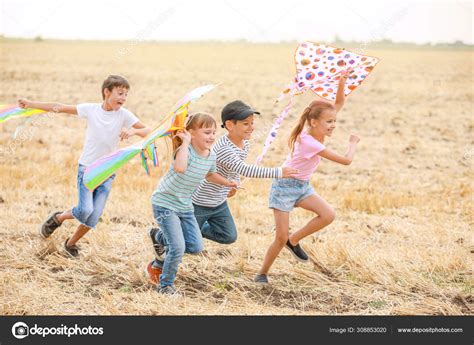 Little children flying kites outdoors Stock Photo by ©serezniy 308853020