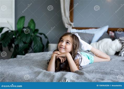 Belle Petite Fille Se Trouvant Sur Le Lit à La Maison Photo Stock