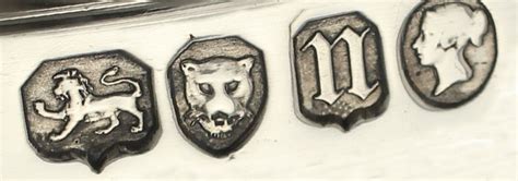 four metal emblems on the side of a white car, depicting lions and dogs