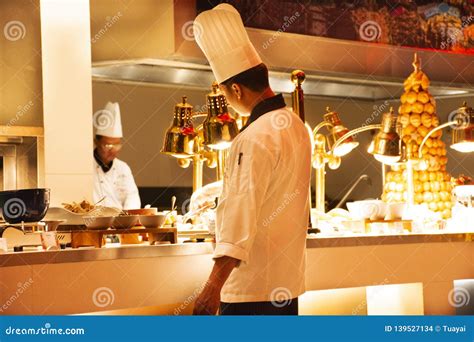 Chef And Assistant Chefs Cooking And Prepared Buffet Food At Restaurant