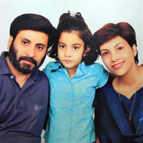 Little Aarushi posing with her mother and father for a family picture ...