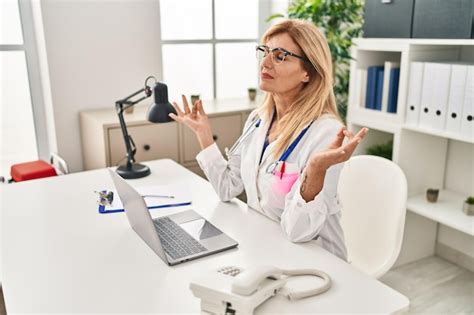 Mujer rubia de mediana edad con uniforme médico haciendo ejercicio de