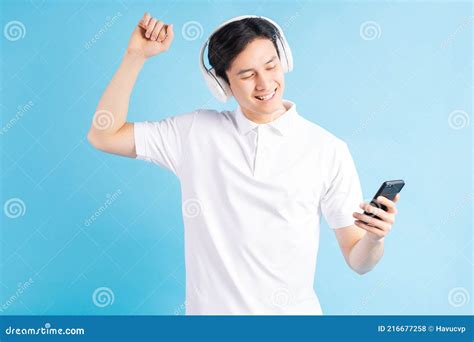 A Photo Of A Handsome Asian Man Listening To Music And Dancing To It