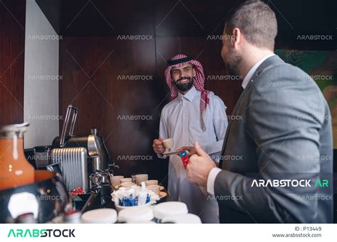 رجل اعمال سعودي خليجي باللباس السعودي التقليدي ، بجانبه زميله بالعمل و