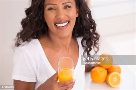 Black Woman Drinking Orange Juice Photos And Premium High Res Pictures