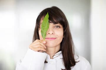 A Female Scientist Meticulously Conducts An Experiment In A Lab With