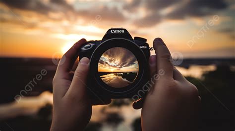 Person Holding A Camera And Taking A Picture Of The Sunset Background