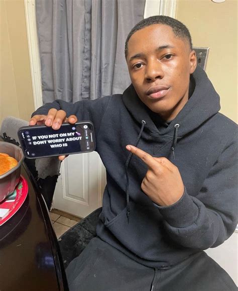 A Man Sitting At A Table With A Remote Control In His Hand And Pointing