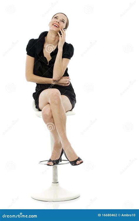 Smart Woman Sitting On A Stool Holding A Cellphone Stock Photo Image