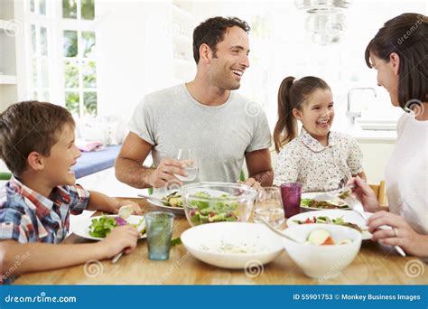 Familia Que Come La Comida Alrededor De La Tabla De Cocina Junto Imagen