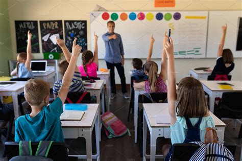 Teacher standing in a classroom | Stock Photos ~ Creative Market