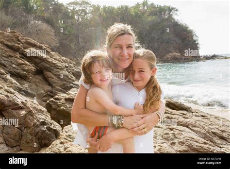 Caucasian Mother Hugging Son And Daughter At Beach Stock Photo Alamy